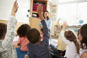 children raising hands at school